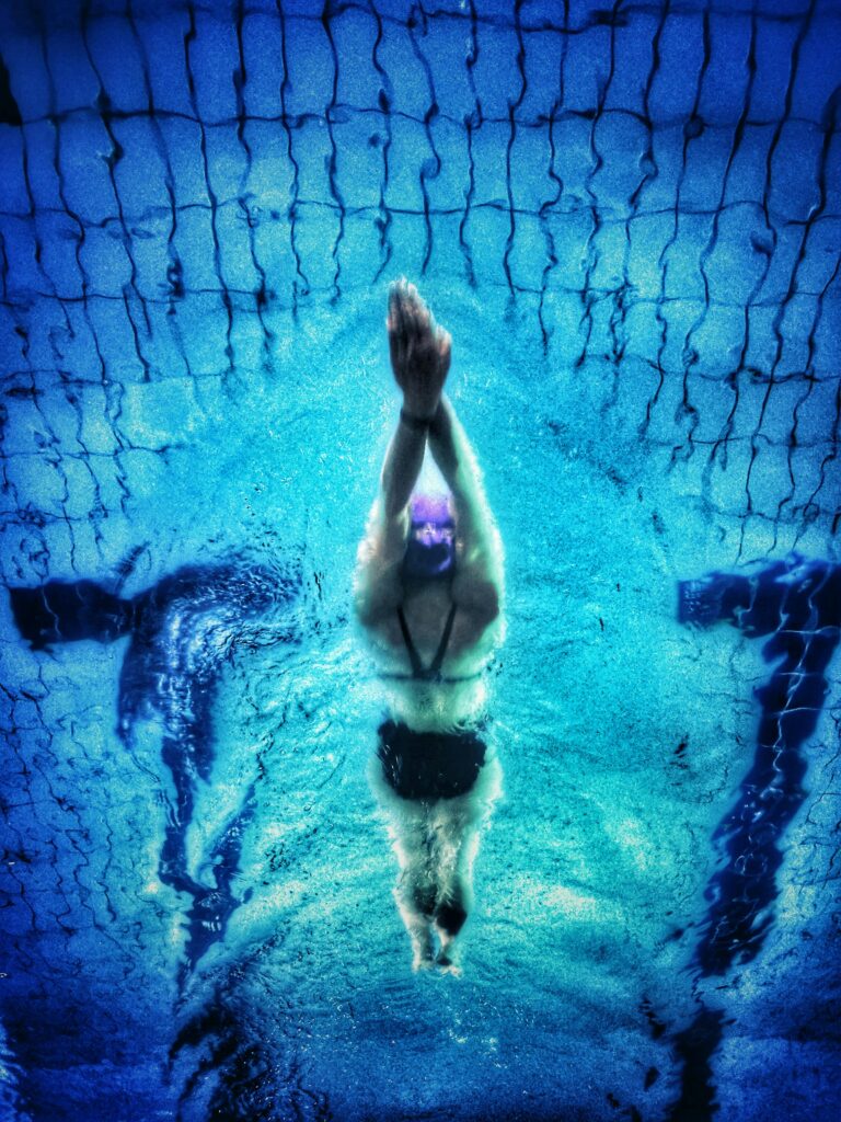 pexels-photo-711187-711187 Captivating underwater shot of a swimmer in a pool with clear blue water.